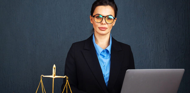 woman in glasses with a laptop and beam scale beside her